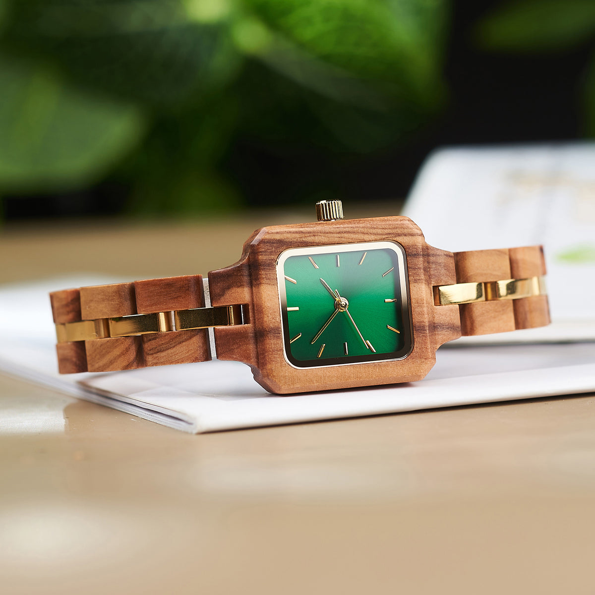 A stylish women's wooden watch with a green dial and gold accents, showcasing its natural wooden design and elegant aesthetic.