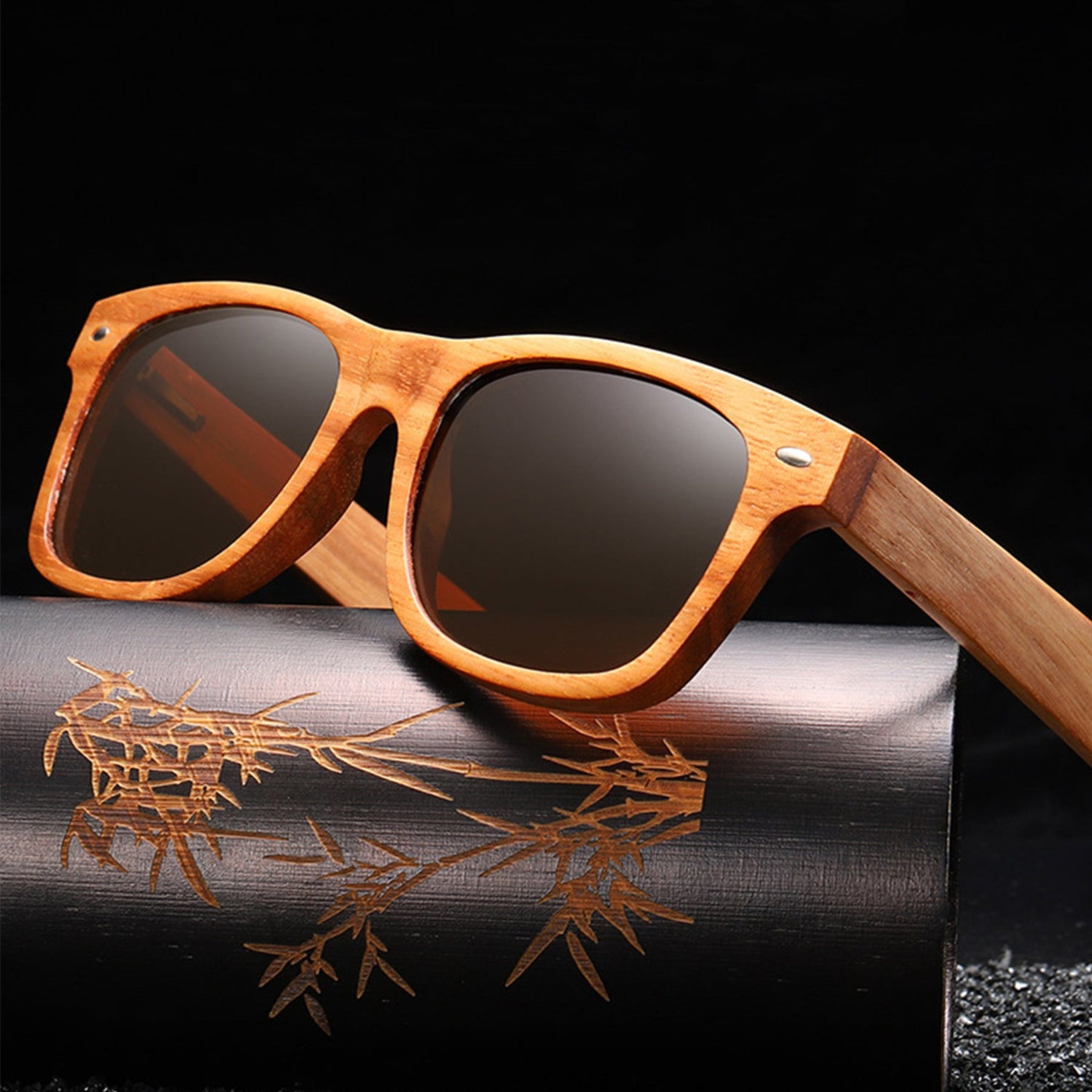 Black lens rosewood sunglasses on a black bamboo box