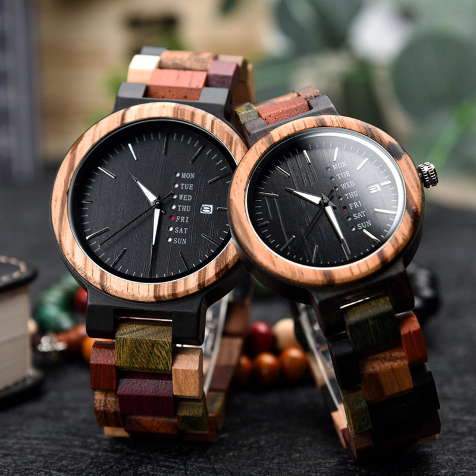 Ebony and colorful strap wooden watches for couples standing on black table