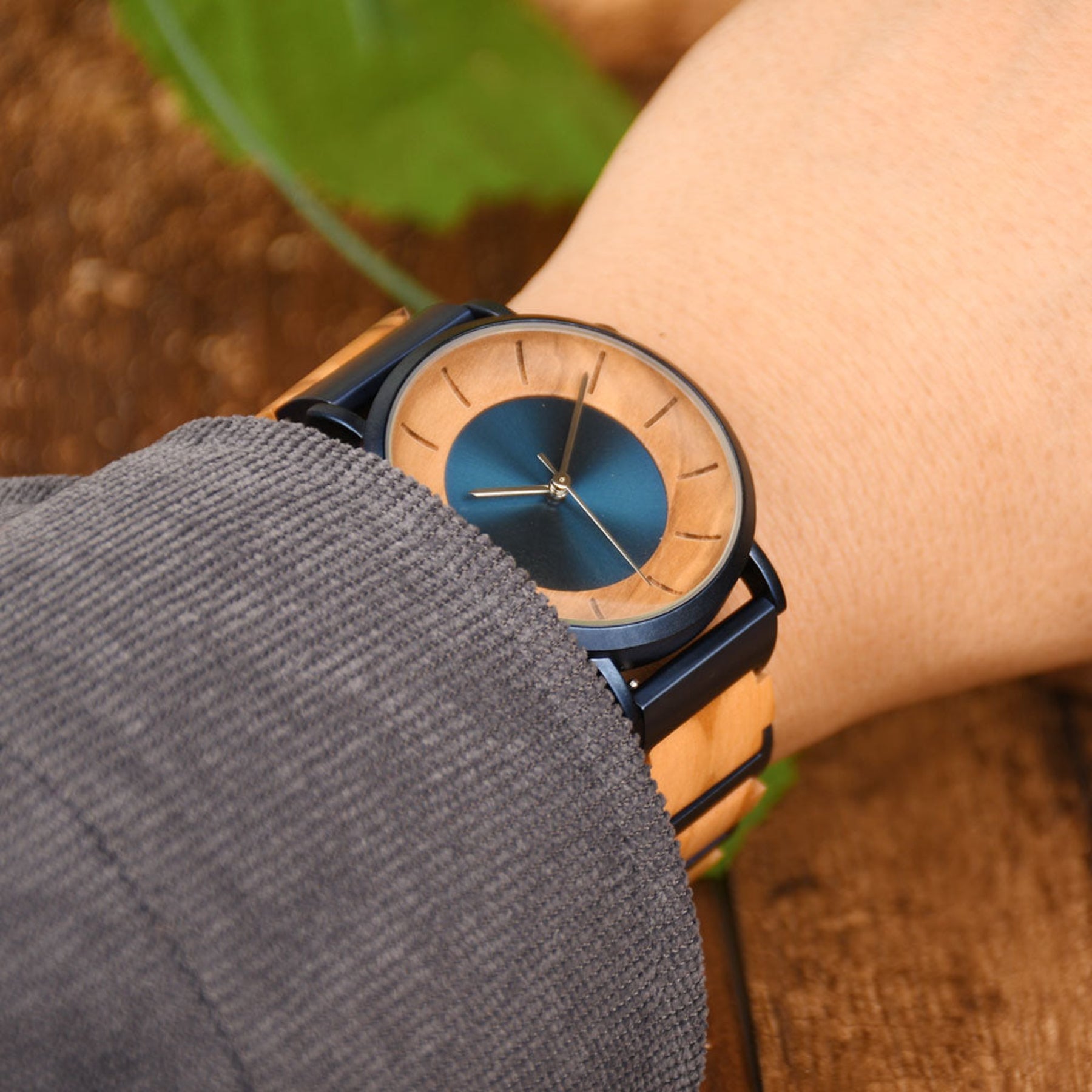 A man wearing a blue and olive minimalist quartz watch