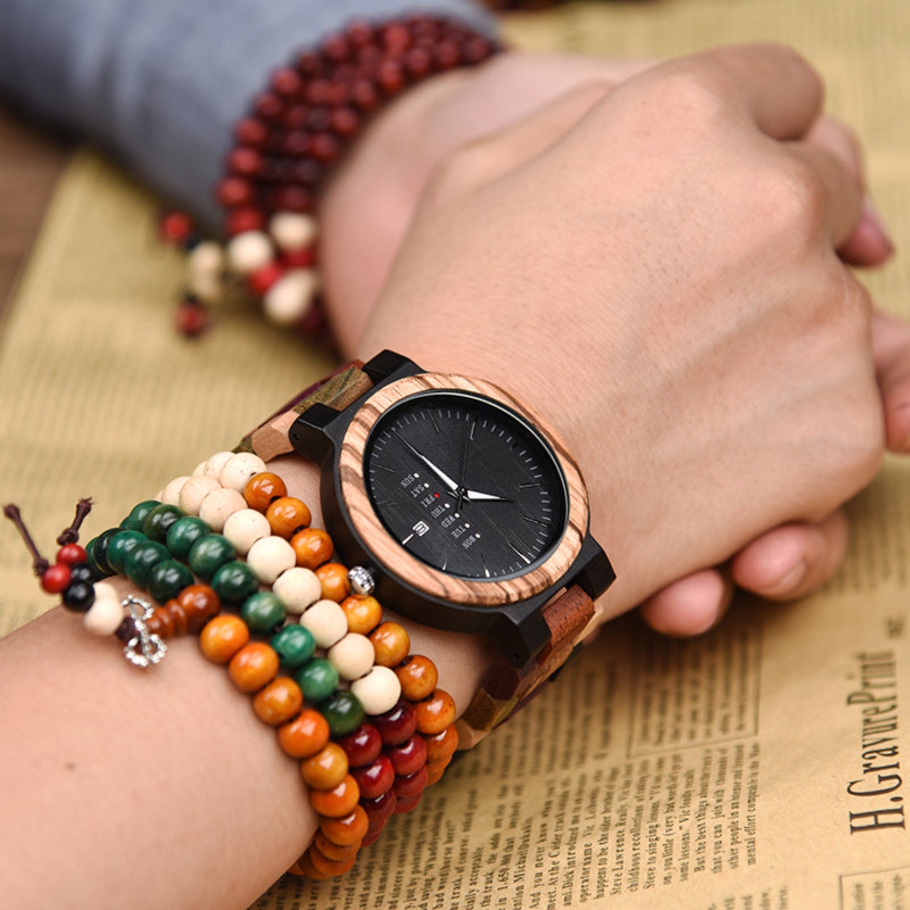A man wearing an ebony and colorful strap wooden watch