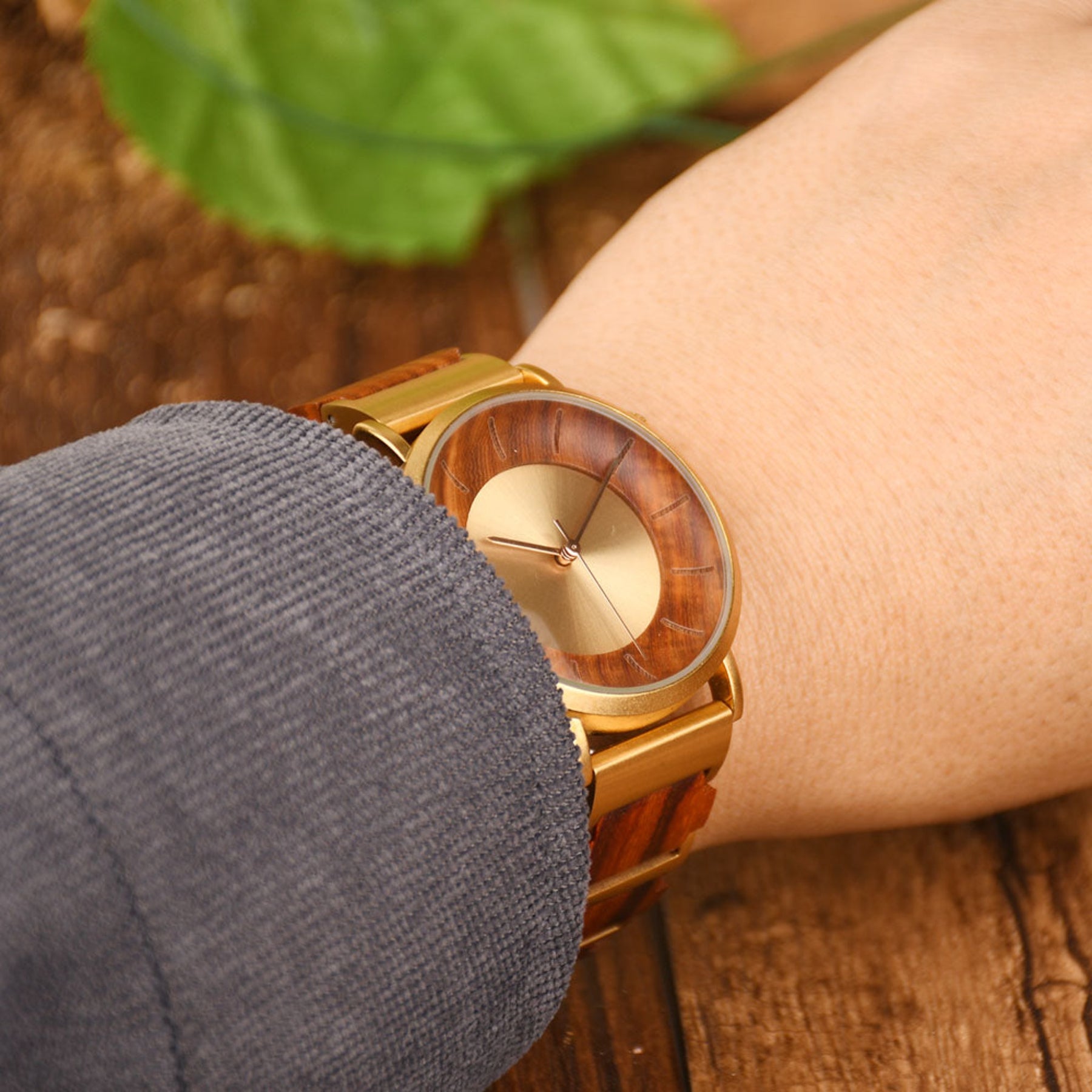 A man wearing a golden steel and red sandalwood watch