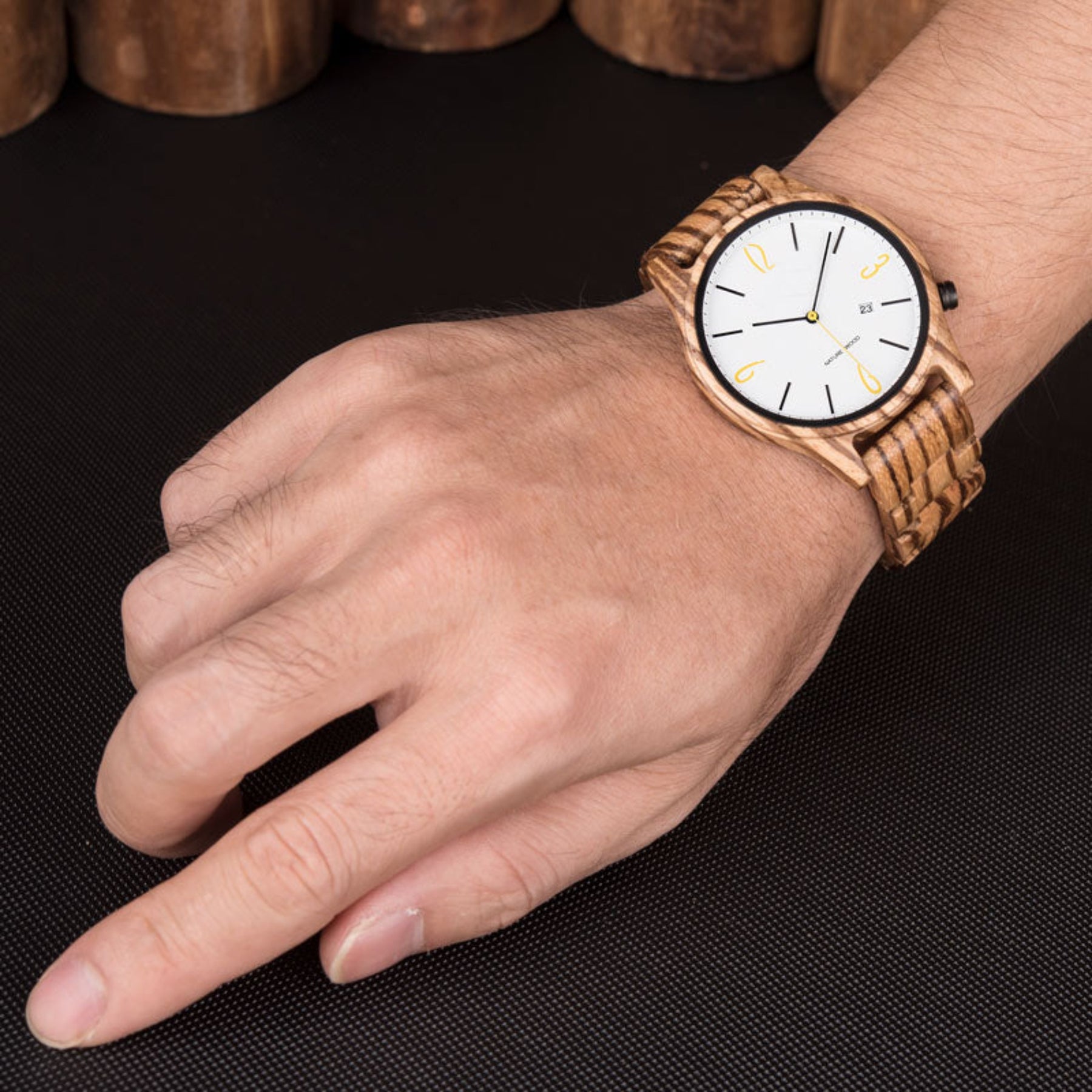 A man wearing a zebrawood simple watch with white face