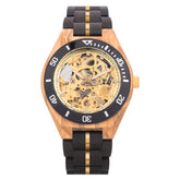 Front view of a wooden wristwatch with a gold full skeleton dial, black and gold accented band, isolated on a white background.