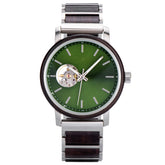 A sophisticated skeleton automatic watch featuring a green dial, wooden bezel, and silver metal with wood combined band, isolated against a white background.