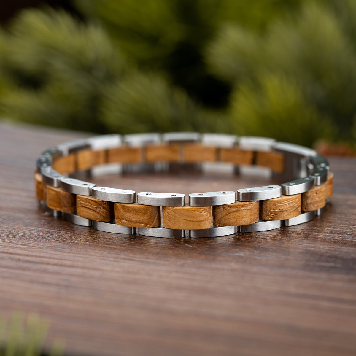 Men's wooden bracelet with stainless steel links on wooden surface, rustic modern design. Ideal for stylish, nature-inspired masculine accessory lovers, perfect for daily wear.
