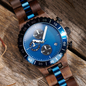 A detailed view of a men's walnut wooden chronograph watch with blue accents, displayed on a wooden surface to emphasize its craftsmanship and sophisticated design.