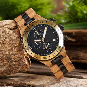 A rugged men's wooden chronograph watch with gold and black accents, displayed on natural wood to highlight its sporty and sophisticated design.