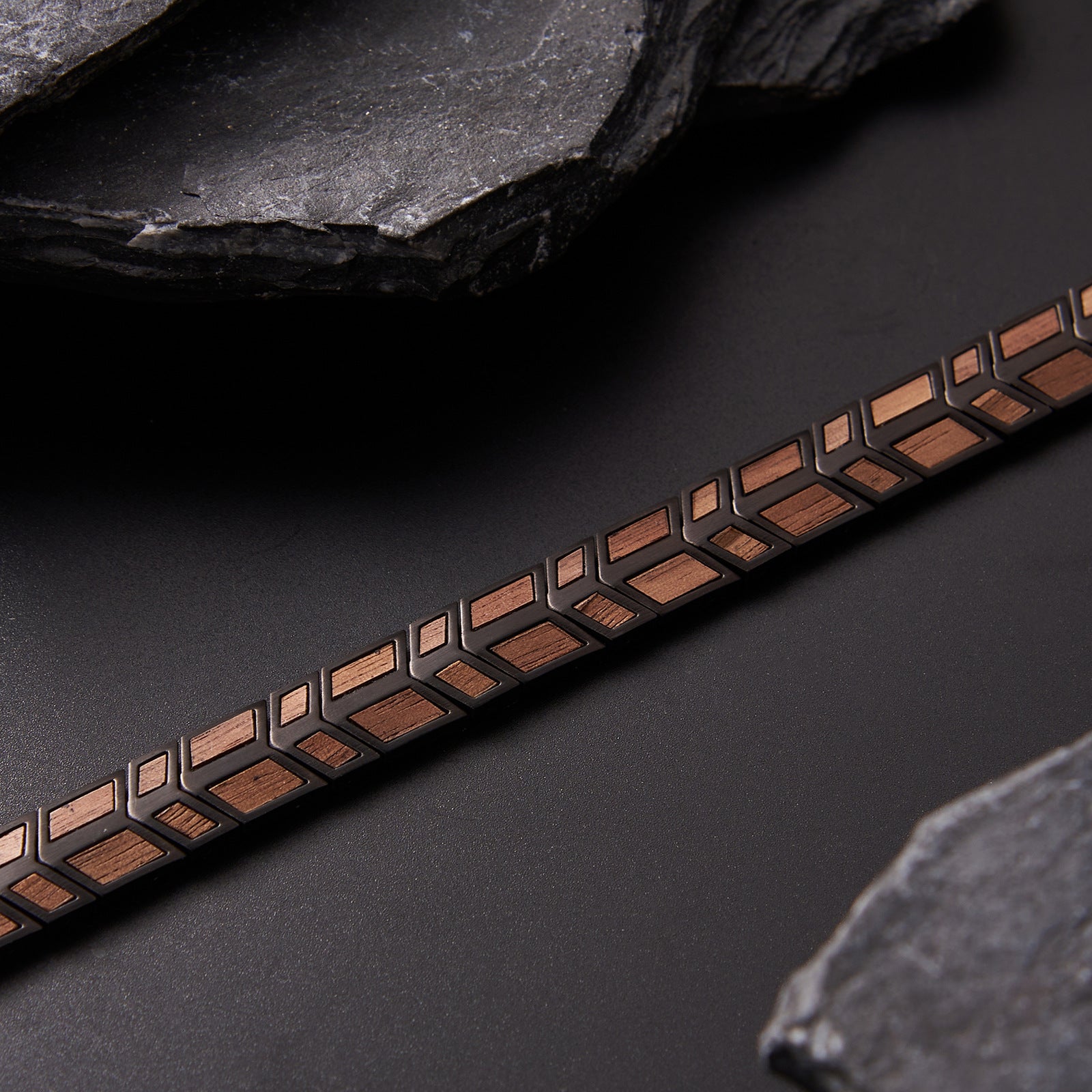 Close - up detail of men's bracelet with black stainless steel and walnut wood, featuring a geometric pattern. Stylish and textured accessory for men, great for fashion and gifting.