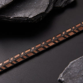 Close - up detail of men's bracelet with black stainless steel and walnut wood, featuring a geometric pattern. Stylish and textured accessory for men, great for fashion and gifting.
