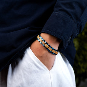Men wearing a stylish bracelet with blue stainless steel and natural oak wood links, paired with a navy jacket, perfect for men's fashion and everyday accessorizing.
