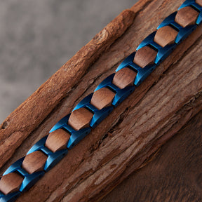Close-up of men's bracelet with blue stainless steel and walnut wood links, placed on natural wood, highlighting its rugged and stylish design for men's fashion.