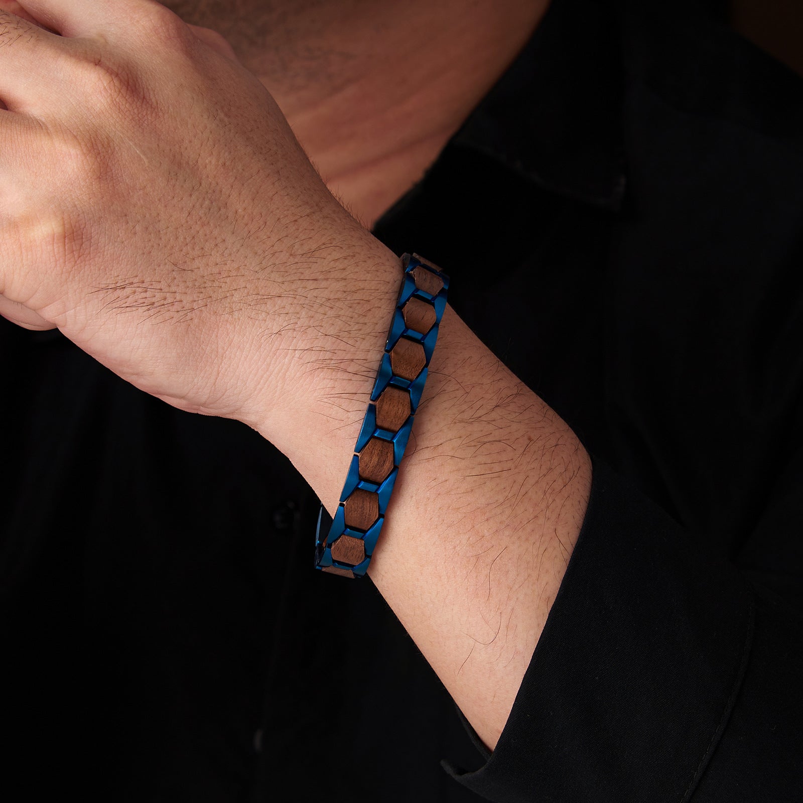 Men wearing a blue stainless steel and walnut wood bracelet, showcasing a sleek and masculine accessory for men's style.