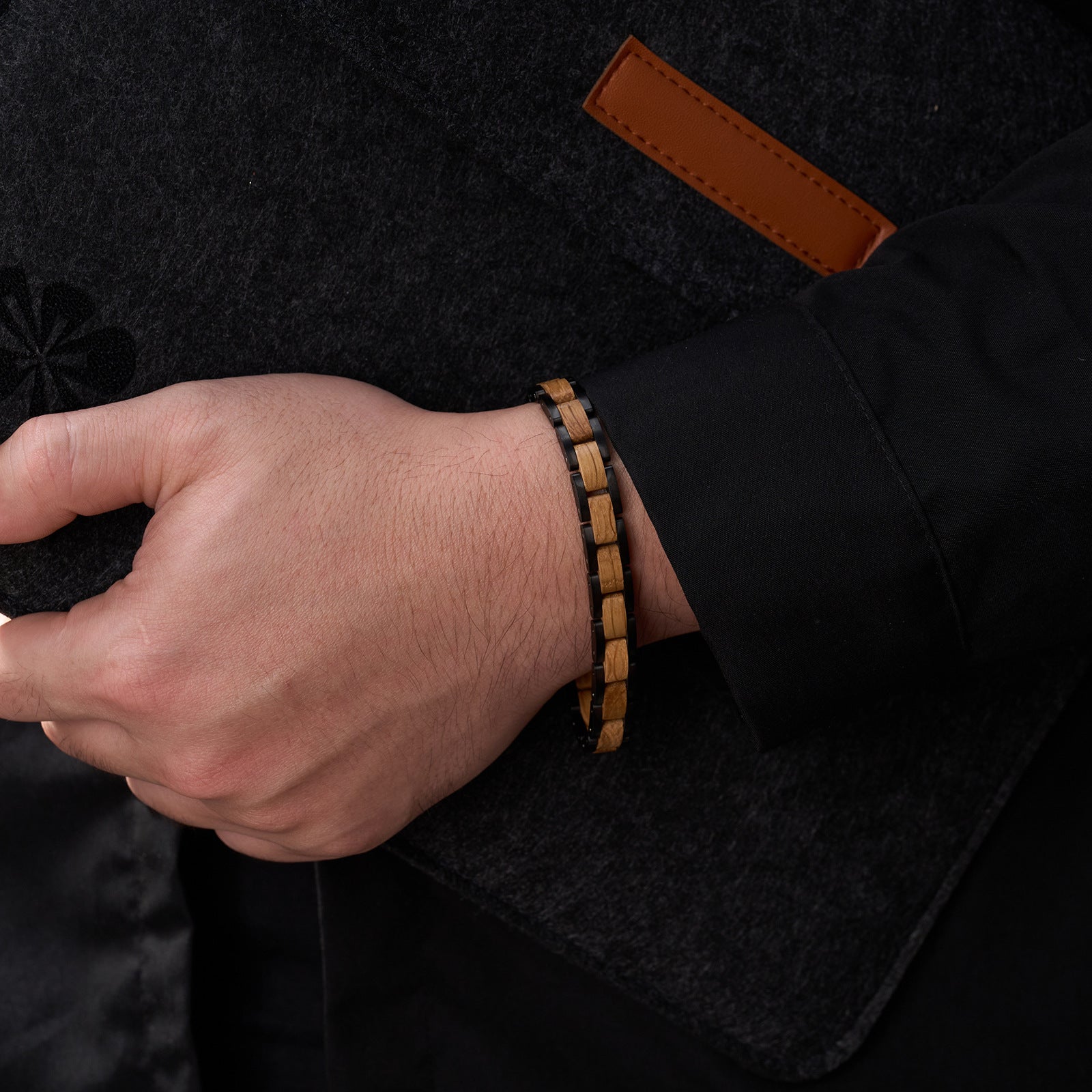 Men's bracelet with oak wood and black stainless steel, showcased on a man's wrist, a trendy and unique accessory for modern men.