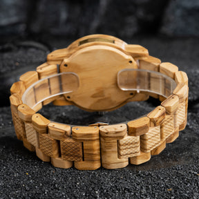 A detailed view of the back and band of a men's wooden watch, showcasing its light brown wood construction and textured details, highlighting the craftsmanship and natural aesthetic.
