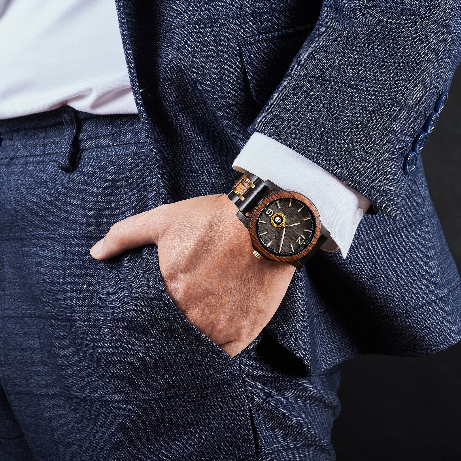 A sophisticated men's wooden watch featuring a dark gray dial, showcased on a wrist wearing a navy suit, emphasizing its elegant and professional aesthetic.