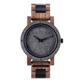 A rugged men's watch featuring a gray stone dial, wooden and black accent band, and industrial design elements, presented against a white background to highlight its masculine and natural aesthetic.