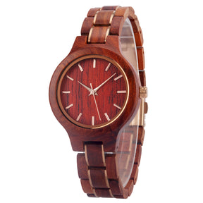 A refined women's rosewood watch with gold-tone accents, shown in side view against a white background to highlight its craftsmanship and elegant design.