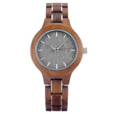 A sophisticated women's walnut watch with silver-tone accents, presented against a white background to highlight its natural wood grain and elegant design.