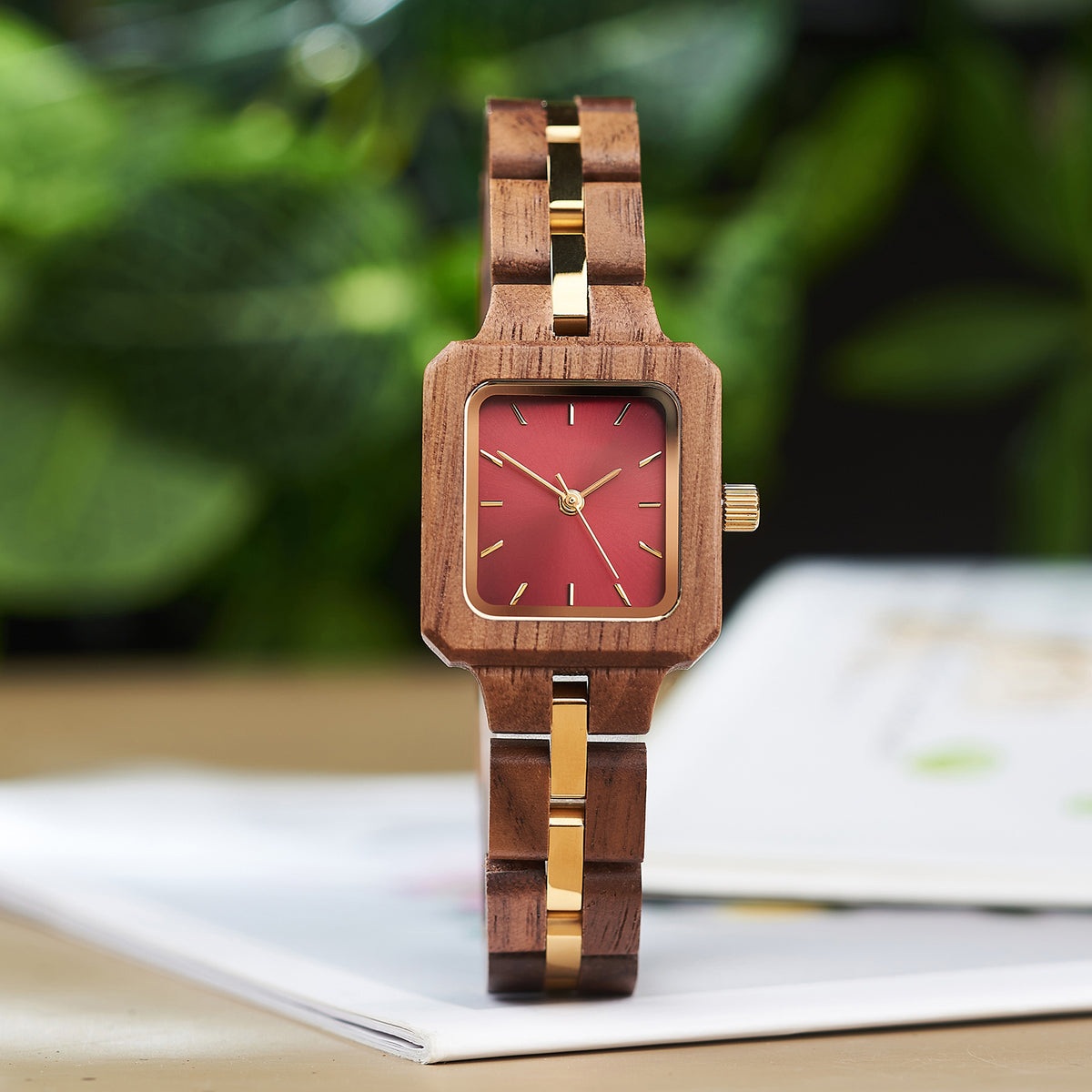 A stylish women's wooden watch with a red dial and gold accents, showcasing its natural wooden design and elegant aesthetic.