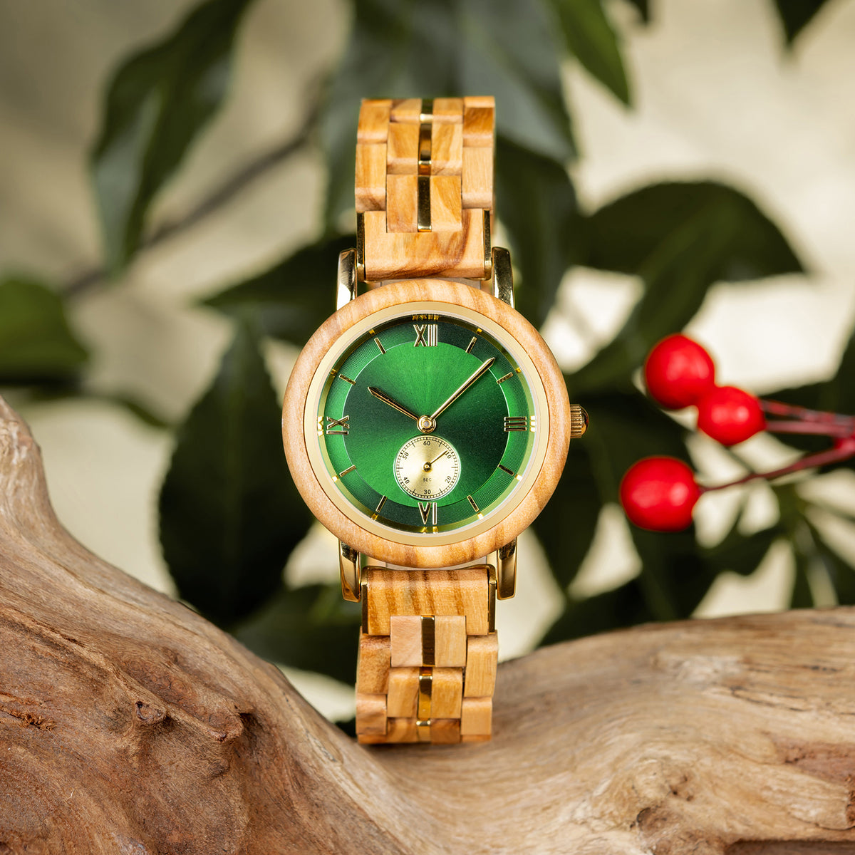 A stylish women's wooden watch featuring a green dial, Roman numerals, sub-dial, and gold-accented details, presented against a backdrop of rustic wood and green foliage to highlight its sophisticated and natural aesthetic.