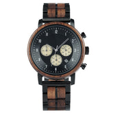 A chronograph watch with a combination of wooden and black metal bracelet, featuring a black dial with beige chronograph sub-dials, numerical hour markers, and a date window, presented against a white background.