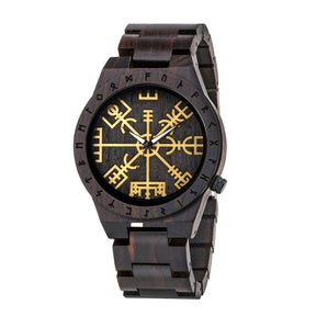 A side view of a dark wooden wristwatch with golden Viking symbols and runes on the dial, displayed against a plain white background.