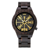 A dark wooden wristwatch with golden Viking symbols and runes on the dial, displayed against a plain white background.