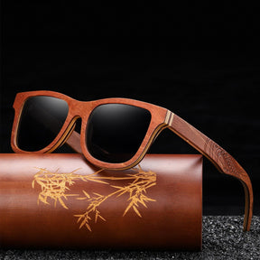Black lens engraved arms walnut sunglasses on a bamboo box