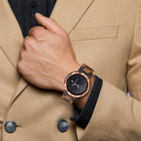 A man wearing a ebony and zebrawood strap wooden watch with black face