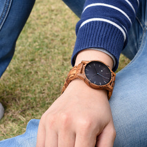 A man wearing a zebrawood men wooden watch with black face