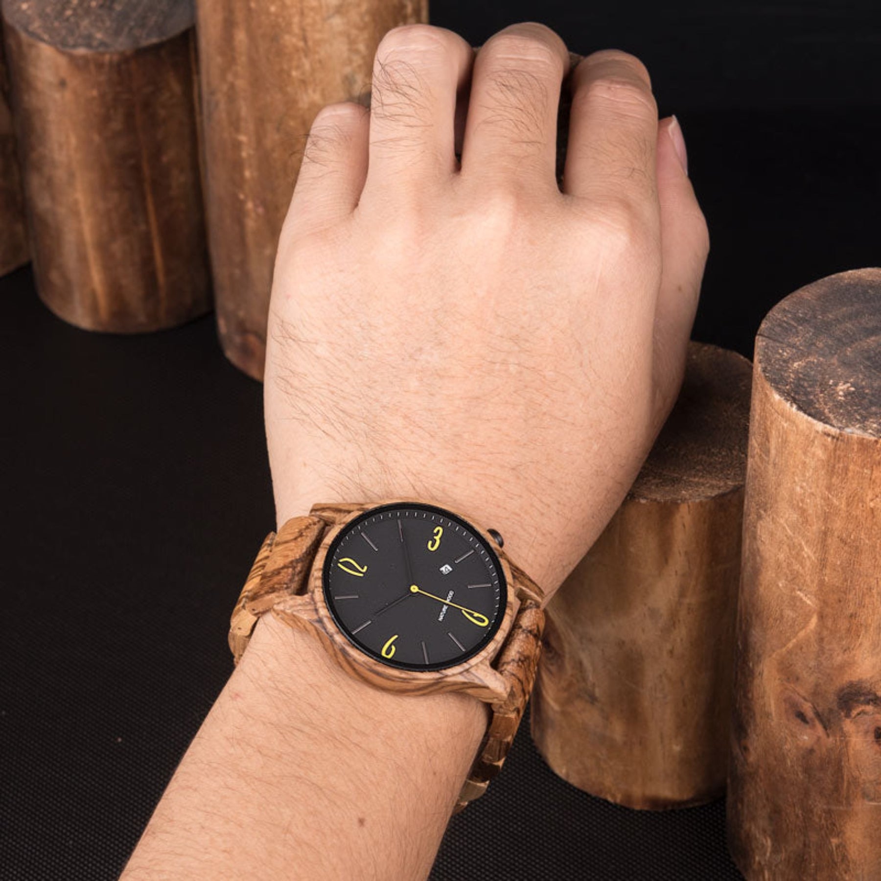 A man wearing a zebrawood quartz watch with black face