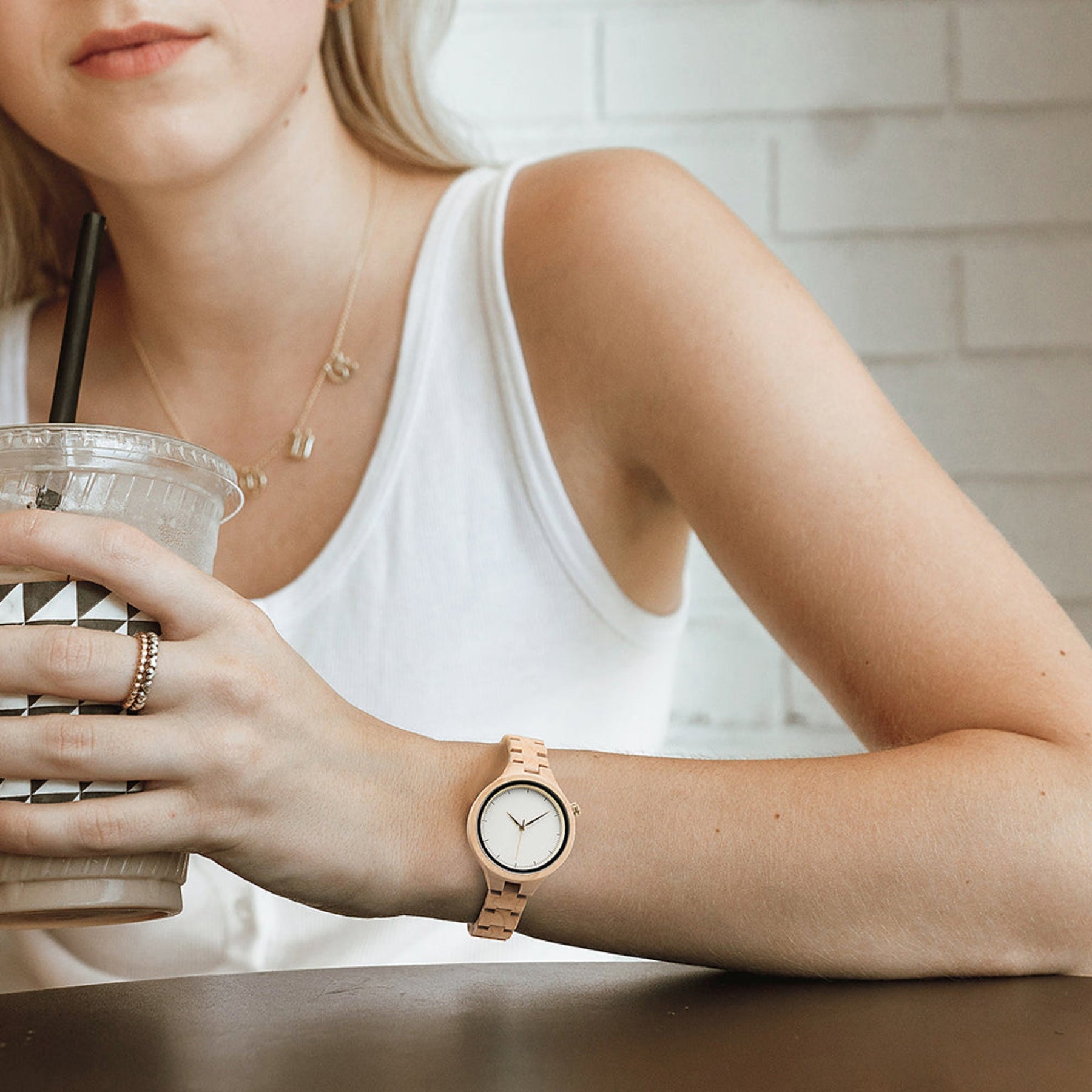A woman wearing a white face maple wood watch