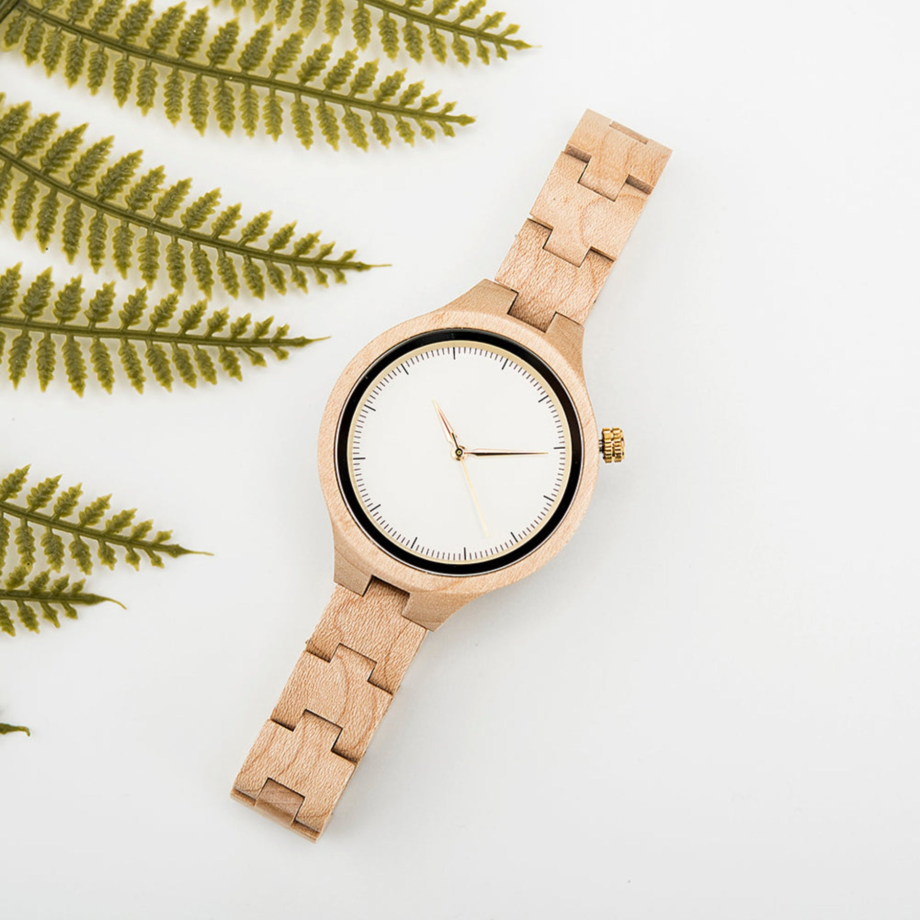 The white face maple women wood watch lying on white table